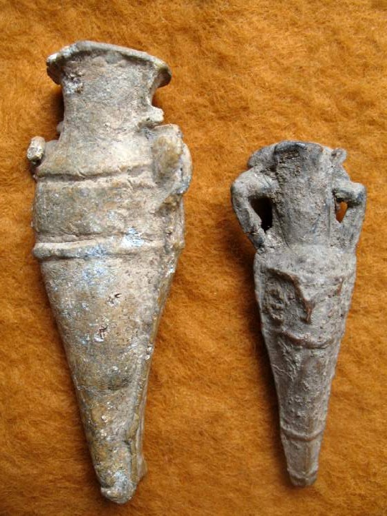 1875. A lead amphora amulet.